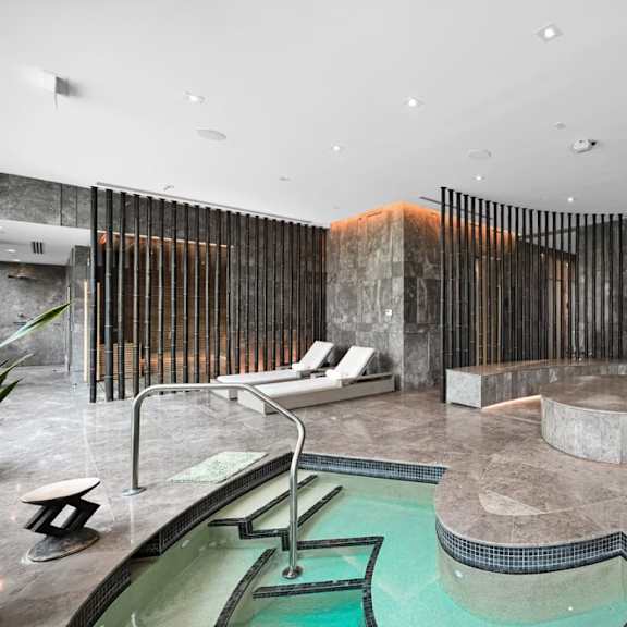 a modern indoor swimming pool with a hot tub.