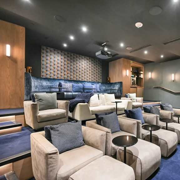 a room with a blue carpet and a row of white couches.
