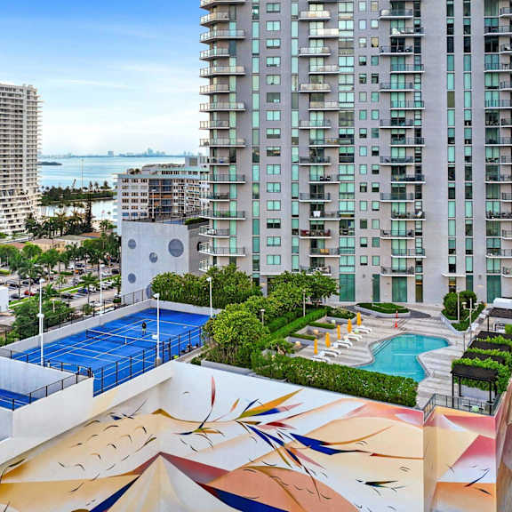 a large building with a pool and a mural on the side.