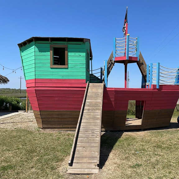 a playground with a slide and a wooden structure.
