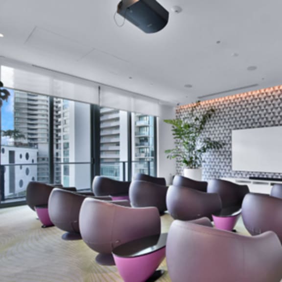 a conference room with a whiteboard and pink chairs.