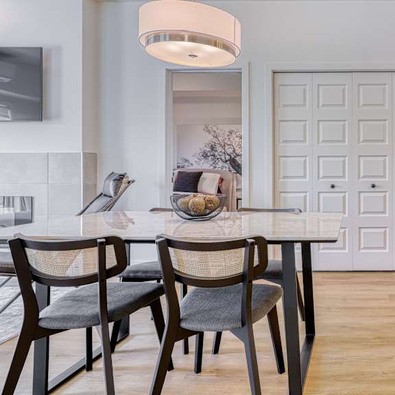 a modern dining room with a white door and a wooden table.
