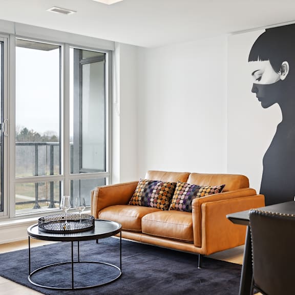 a living room with a couch, a coffee table, and a large picture of a woman on the wall at the dale apartments , ottawa, k1y 4y5