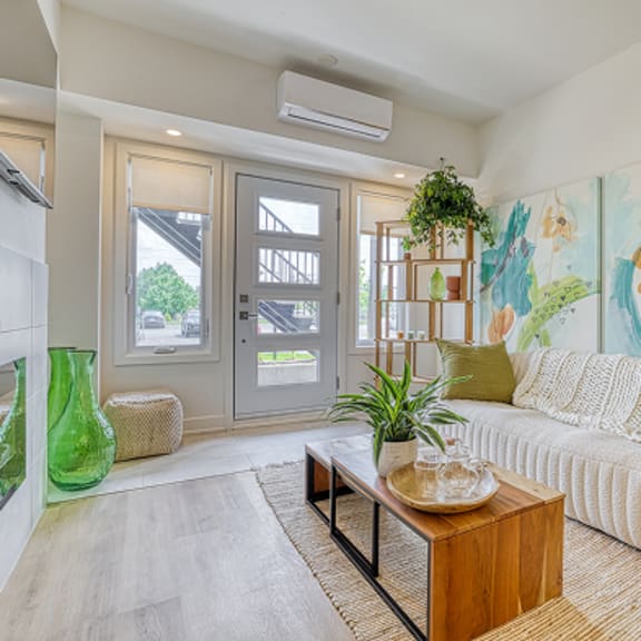 a living room with a white couch and a painting on the wall.