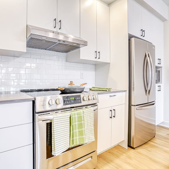 a kitchen with white cabinets and a stainless steel stove.