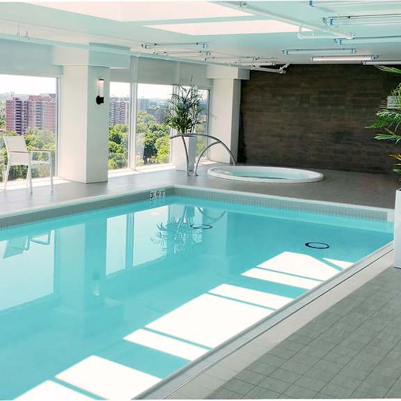 a modern indoor swimming pool with a view of the city.