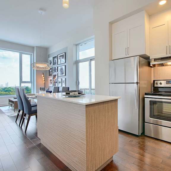 a modern kitchen with a wooden island and stainless steel appliances.