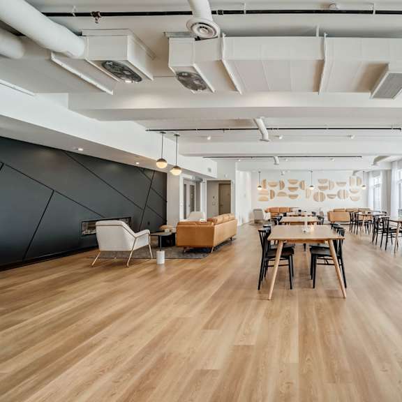 a spacious room with wooden floors and tables set up for a meeting.
