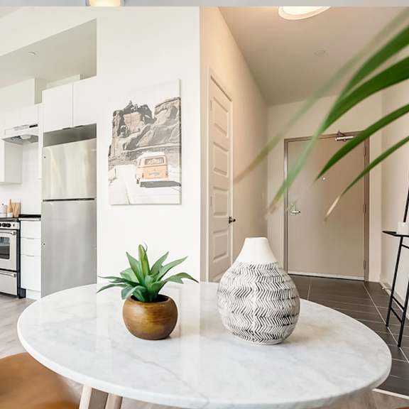 a modern kitchen with a white table and a plant on it.