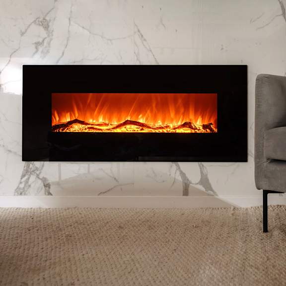 a modern fireplace with a grey couch in front of it.