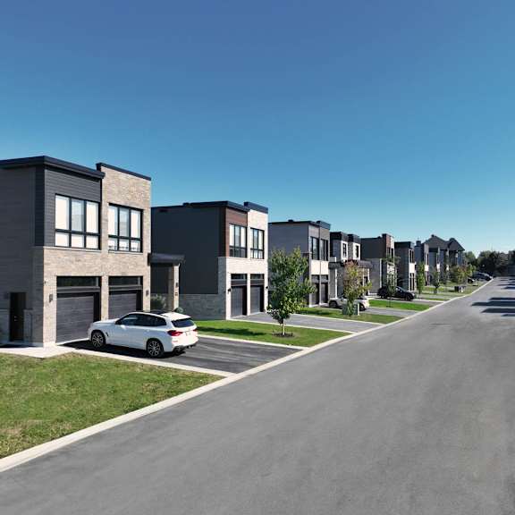 a row of modern houses with a car parked in front of the first house.