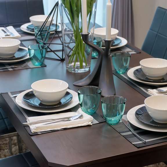 a dining table set with plates, glasses, and cutlery.