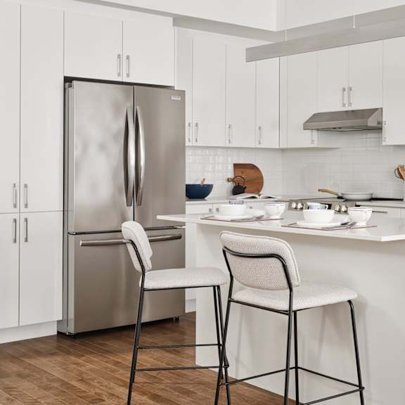 a kitchen with white cabinets and a stainless steel refrigerator.
