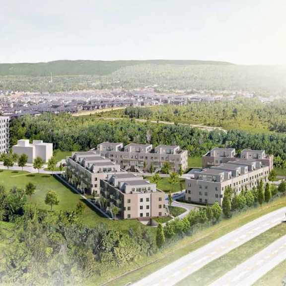 a large, modern building complex is surrounded by smaller buildings and greenery.