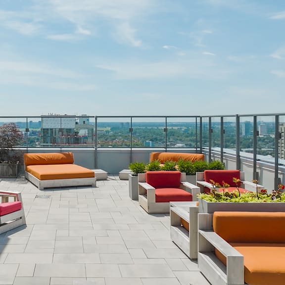 a patio with orange and red couches and a view of the city at the dale apartments , ontario, k1y 4y5