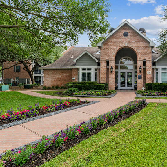 a brick building with a green lawn in front.