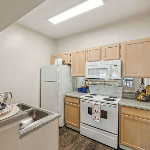 a kitchen with a white refrigerator, white oven, and wooden cabinets.