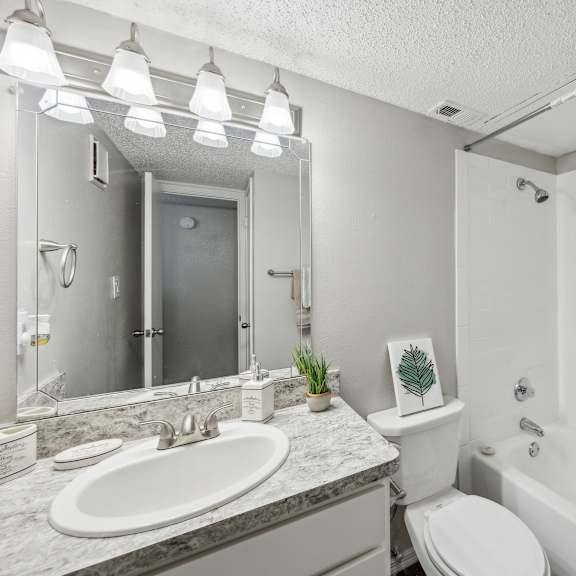a bathroom with a white toilet, sink, and shower curtain.
