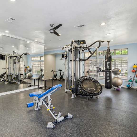a spacious gym with a variety of equipment including a treadmill, weights, and a bench press.