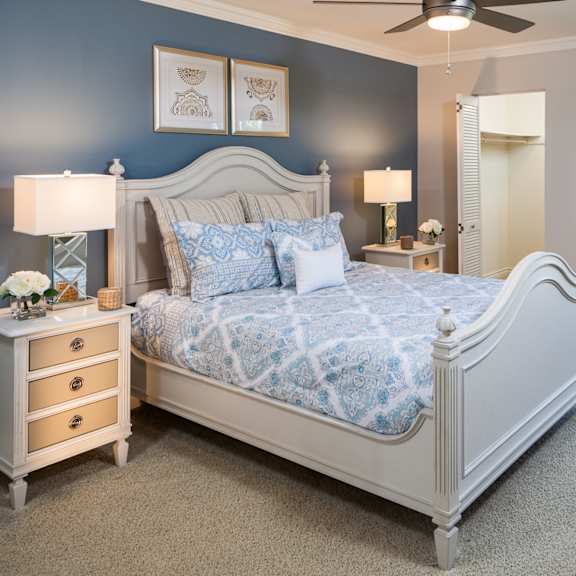 a bedroom with a large bed, a dresser, and a ceiling fan.