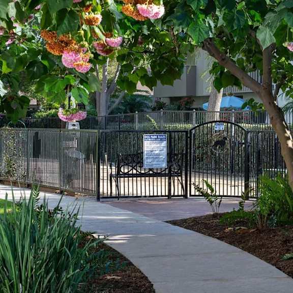 a pathway with a sign and a fence in the background.