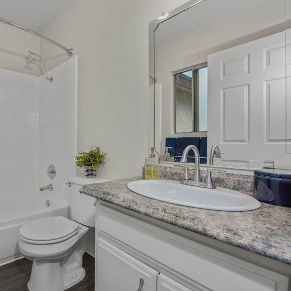 a white toilet sits in a bathroom next to a sink.