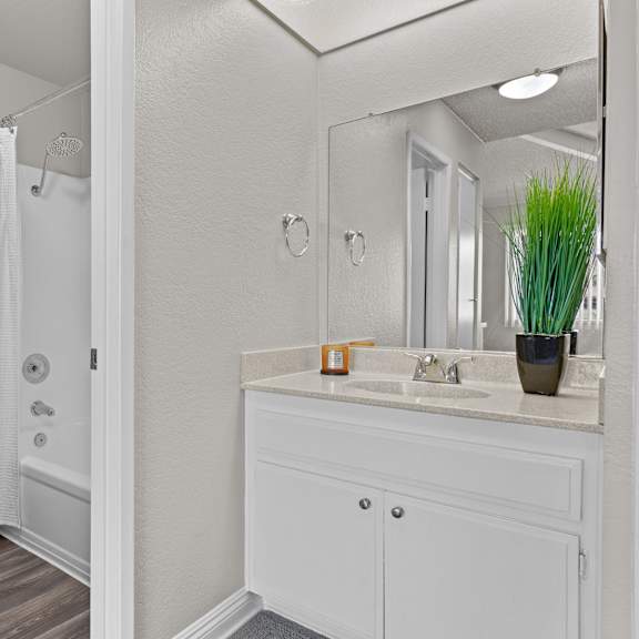 a white bathroom with a toilet, sink, and shower.