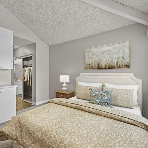 a bedroom with a bed, nightstand, and a painting on the wall.