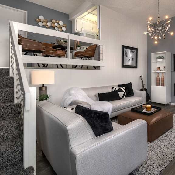 a modern living room with a grey couch and a fireplace.
