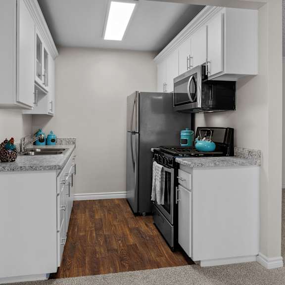 a kitchen with white cabinets and a black refrigerator.