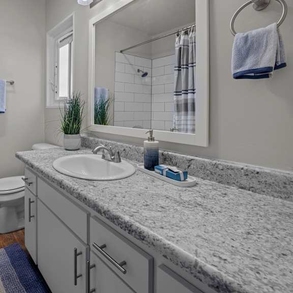a bathroom with a toilet, sink, and mirror.