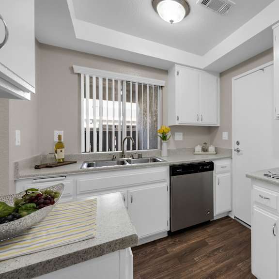 a modern kitchen with white cabinets and a black stove top.
