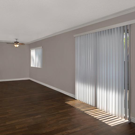a living room with sliding glass doors covered by tall blinds.