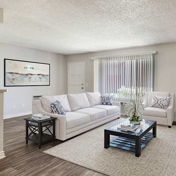 a living room with a white couch, a coffee table, and a painting on the wall.