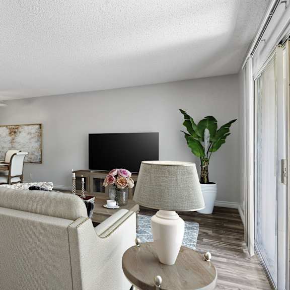 a living room with a beige couch, a coffee table, and a television.