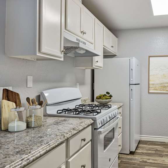 a kitchen with a white stove top oven and a white refrigerator.