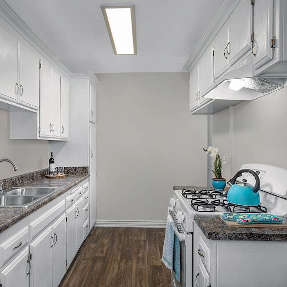 a kitchen with white cabinets and a granite countertop.