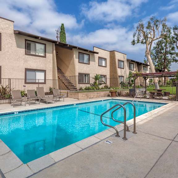 a swimming pool in front of apartment buildings.