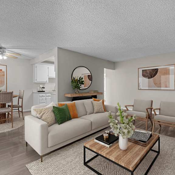 a living room with a white couch, wooden coffee table, and a dining table with chairs.