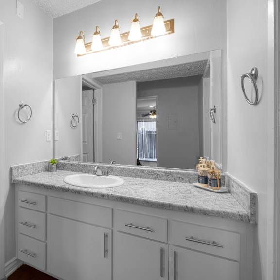 a bathroom with a marble countertop and a white sink.