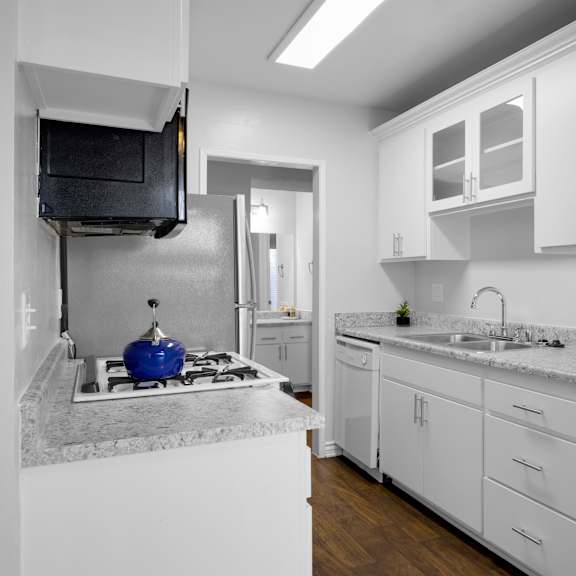 a kitchen with white cabinets and a granite countertop.