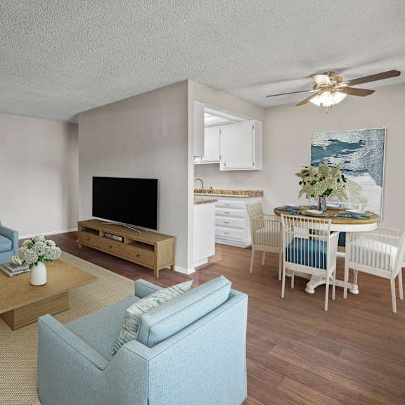 a living room with a white couch, blue armchair, and a wooden coffee table.