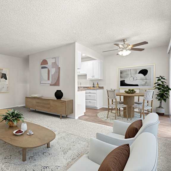 a living room with a white couch, a coffee table, and a ceiling fan.