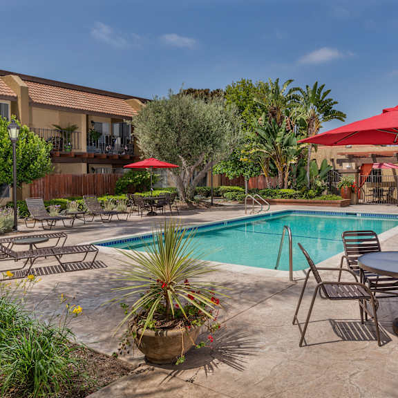 a poolside patio with a table and chairs.