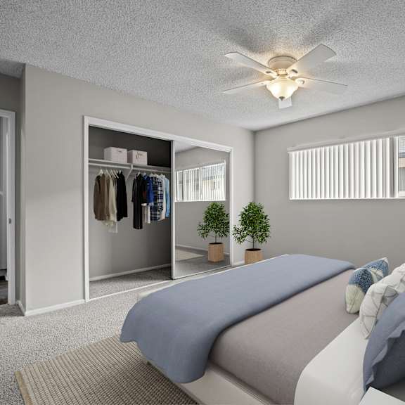 a bedroom with a bed, pillows, a ceiling fan, and a closet.
