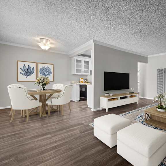a living room with a white couch, a wooden coffee table, and a television.
