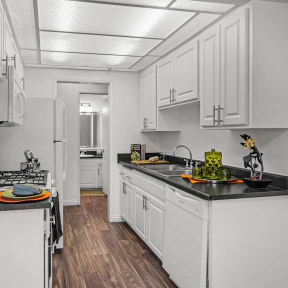 a kitchen with white cabinets and a black countertop.