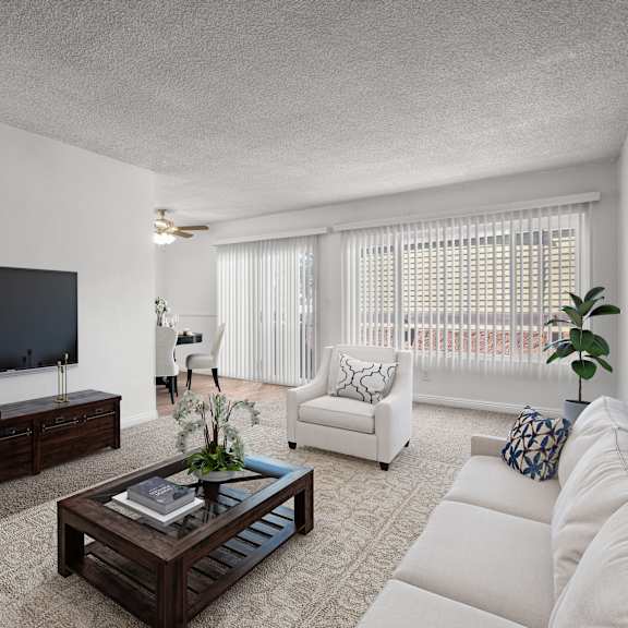 a living room with a white couch, a wooden coffee table, and a flat-screen tv.