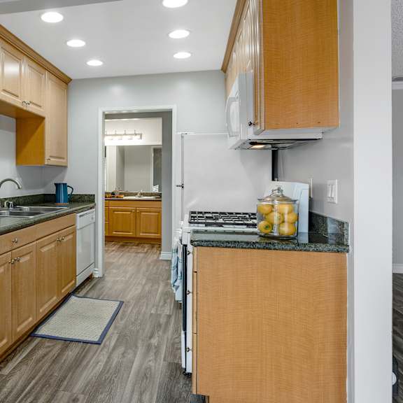 a kitchen with wooden cabinets and granite countertops.