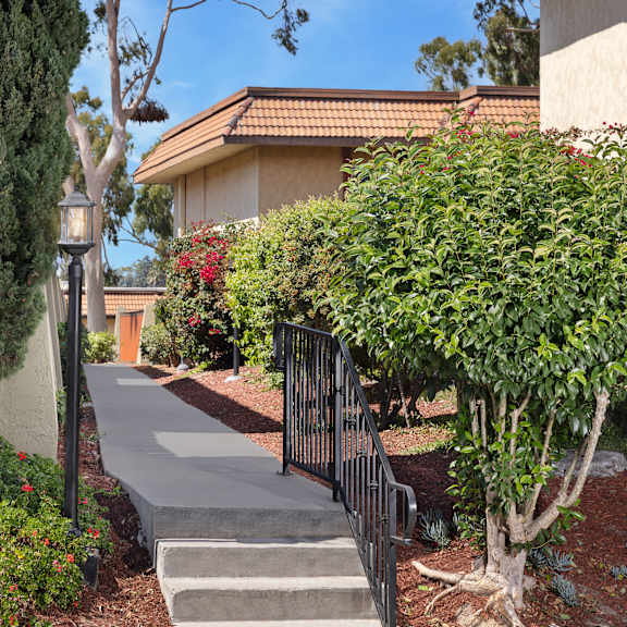a residential area with a house, trees, and a small garden.